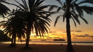 Atardecer en la Playa de Las Teresitas, Tenerife, con palmeras y cruceros fondeados frente a la costa