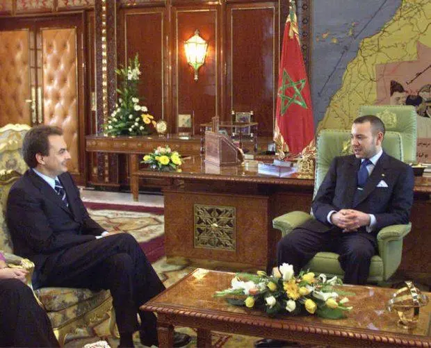 Mohamed VI durante una reunión oficial en su despacho de Rabat en 2001, con la bandera de Marruecos y un gran mapa al fondo